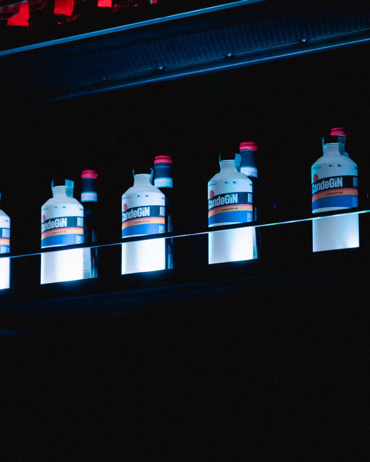 CandeGin bottles lit up on the bar shelf